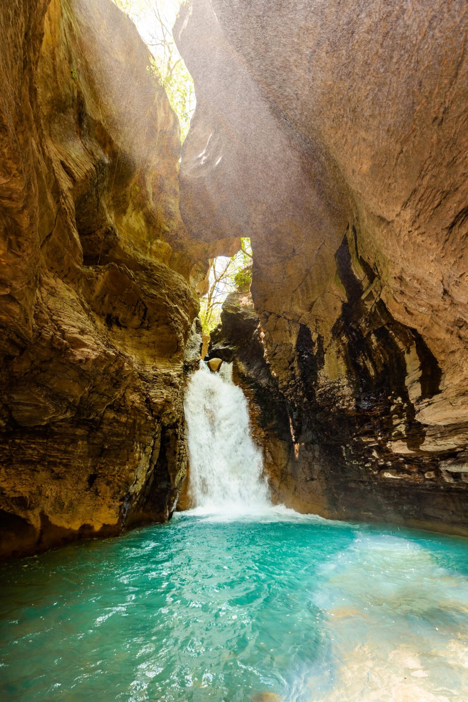 A tourist standing next to La Leona waterfall